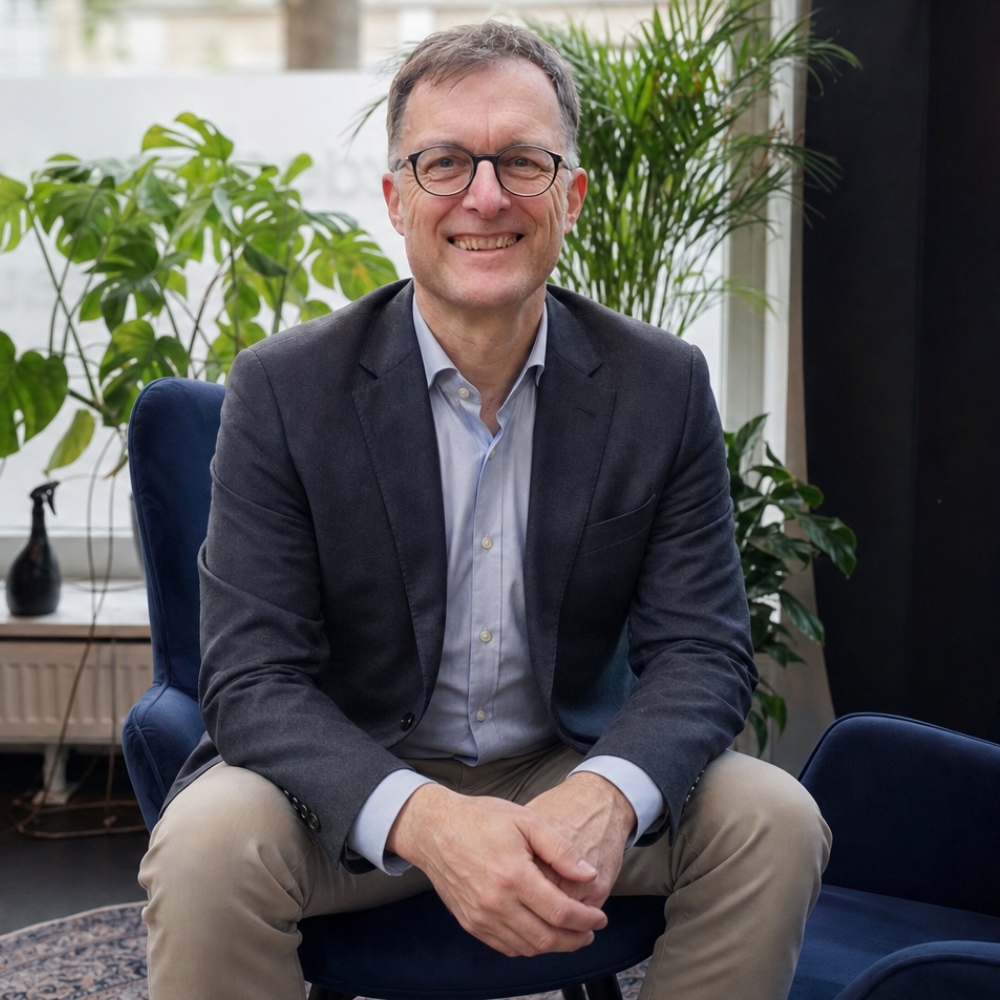 eventbrite (7) Dr. Baum sitzt auf einem Sessel in seinem Raum